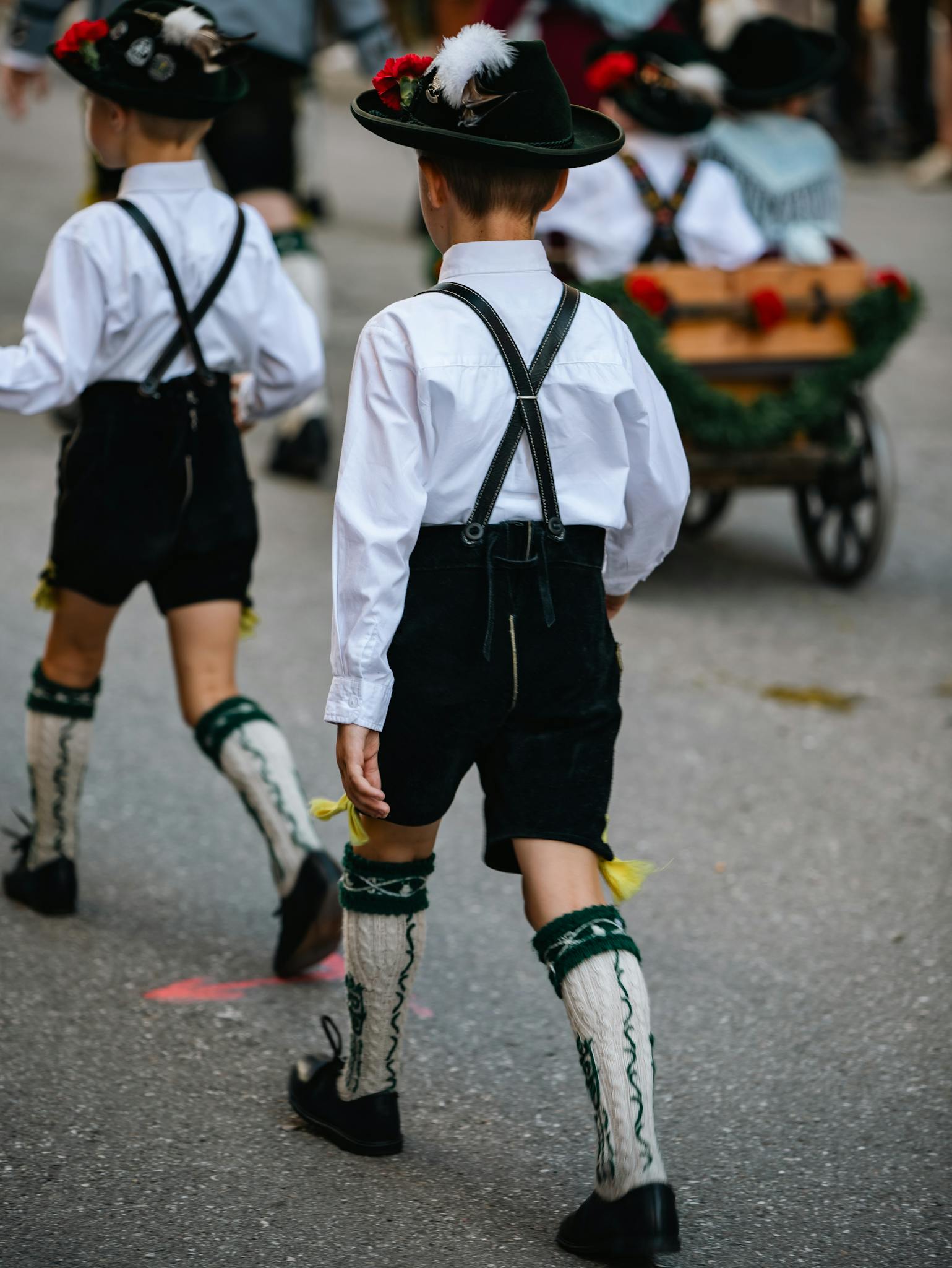 Children in traditional Bavarian attire parading in Munich during a festive event.
